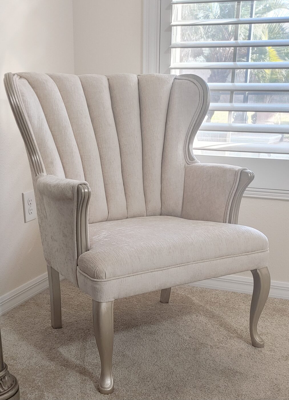 Wingback chair reupholstered in a light natural-weave fabric with a silver-finished frame